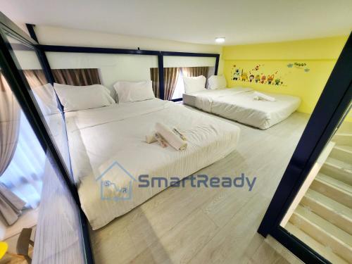 two beds in a hotel room with white sheets at Sunway GRID by SR Home in Kampong Pendas