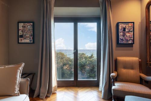 a living room with a large glass door with a view at Sunset Villa in Castiglione della Pescaia