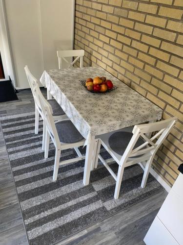 a table with chairs and a bowl of fruit on it at Videdal apartment 2 rooms - Own entrance & Free Parking in Malmö