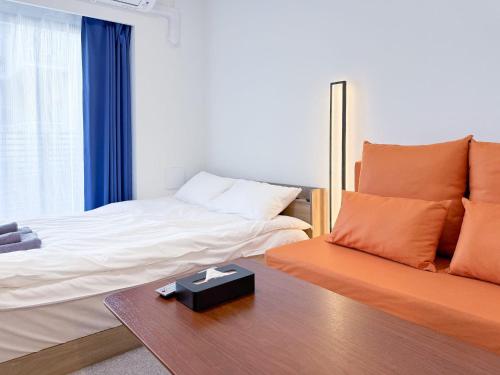 a bedroom with a bed and a table with a table at Triphome Higahsi Shinjuku Brand New in Tokyo