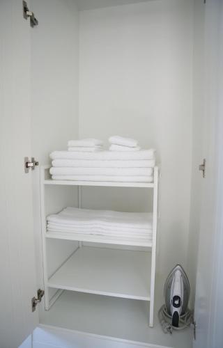 a white shelf with towels on it in a bathroom at Playa Marinsa Torre del Mar in Torre del Mar