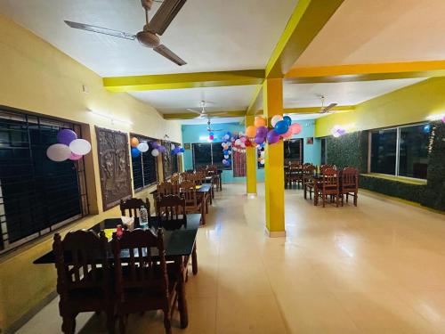 桑蒂尼盖登Gitanjali Hotel & Restaurant的一间带气球和桌椅的用餐室