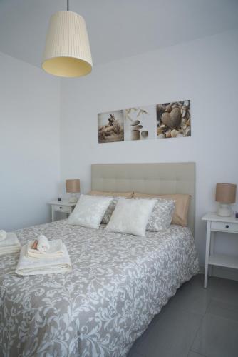 a bedroom with a bed with a blanket and pillows at Playa Marinsa Torre del Mar in Torre del Mar