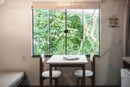 a table and two chairs in front of a window at Bonito Paraiso Ilha Grande in Abraão