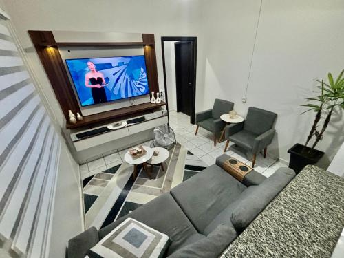 a living room with a couch and a tv at Hospedagem Domiciliar em Lucas do Rio Verde in Lucas do Rio Verde