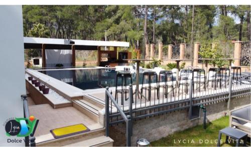 a swimming pool with a deck with benches and a building at LYCIA DOLCE ViTA OLYMPOS ANTALYA in Kumluca