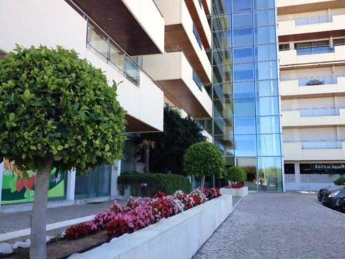 a building with a row of flowers in front of a building at VilamouraSun Aquamar Penthouse 601 in Quarteira