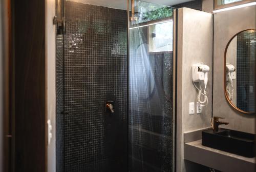 a bathroom with a glass shower with a sink at Bonito Paraiso Ilha Grande in Abraão