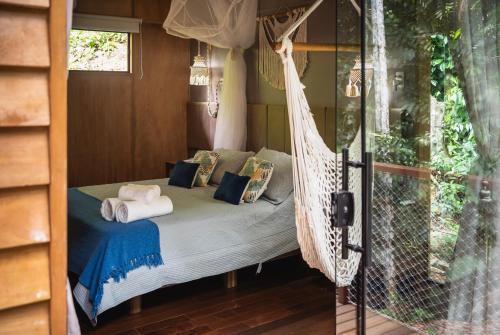 a hammock bed in a room with a window at Bonito Paraiso Ilha Grande in Abraão