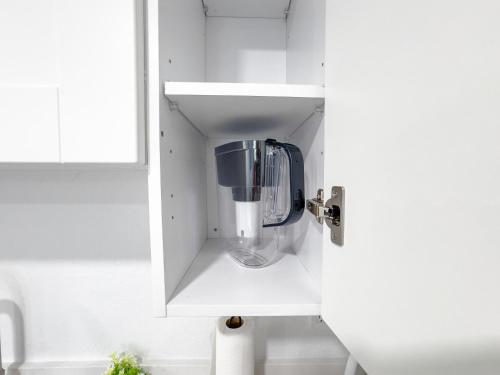 Un armario blanco con una licuadora dentro. en Mins from Disney Gym Pool Parking Pet Friendly, en Kissimmee