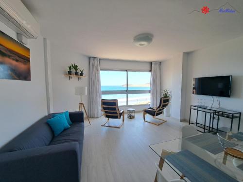 ein Wohnzimmer mit einem blauen Sofa und Meerblick in der Unterkunft MarMédano Apartamento 2 in El Médano