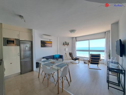 eine Küche und ein Wohnzimmer mit Tisch und Stühlen in der Unterkunft MarMédano Apartamento 2 in El Médano
