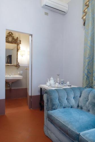 a living room with a blue couch and a table at Villa Poggio Bello in Florence