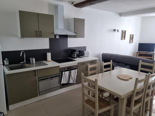 une cuisine avec une table et un évier et une table et des chaises dans l'établissement T3 Macon Centre Rambuteau, à Mâcon