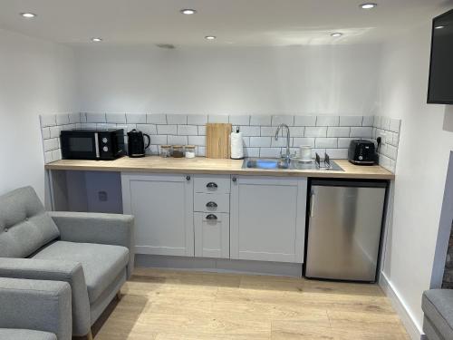 a kitchen with a counter with a sink and a microwave at UG Apartment in Bangor