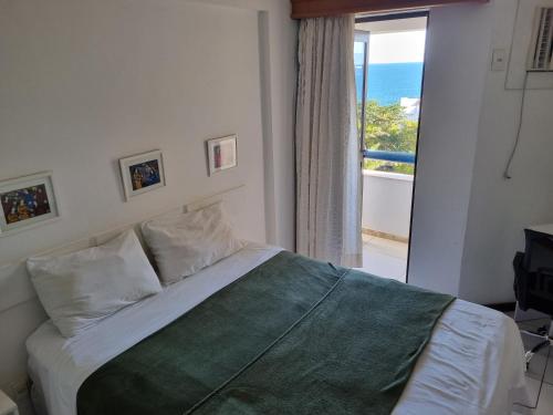 a bedroom with a bed with a view of the ocean at Atlantic City Apart in Salvador