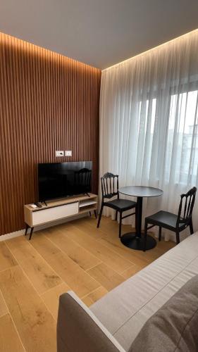 a living room with a tv and a table and chairs at Tirana Central Apartments in Tirana
