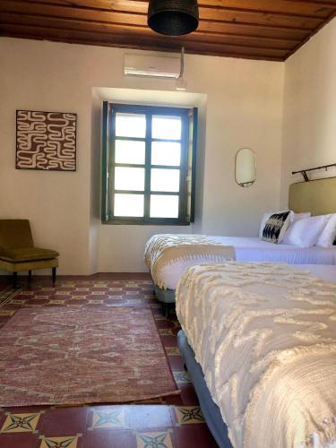 a bedroom with two beds and a window at Mestizo Antigua Cortijo in Ciudad Vieja
