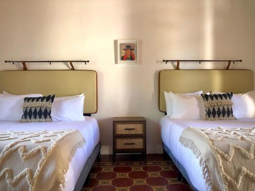 two beds sitting next to each other in a room at Mestizo Antigua Cortijo in Ciudad Vieja