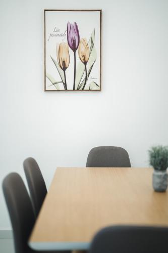 a dining room table with a picture of flowers at Karnayo apartments in Kavala