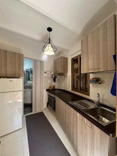 a kitchen with wooden cabinets and a white refrigerator at Casa Giampà in Satriano