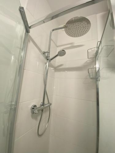 une douche avec pommeau de douche dans une salle de bain dans l'établissement Appartement à 10 min du Stade de France, à Saint-Denis