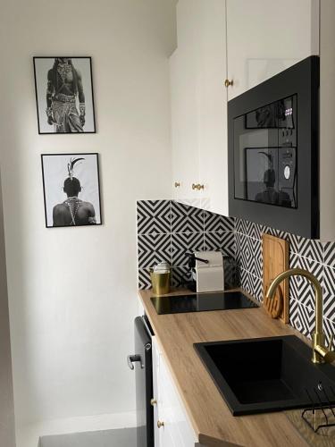 une cuisine avec un évier et un plan de travail dans l'établissement Appartement à 10 min du Stade de France, à Saint-Denis