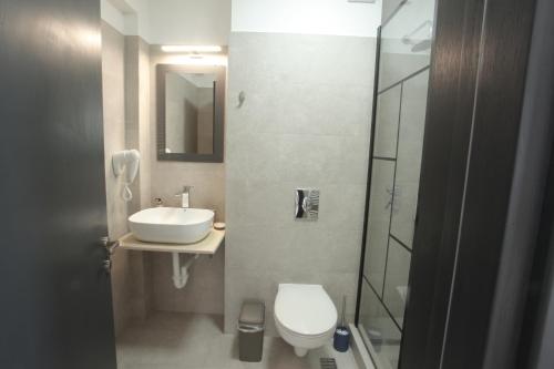 a bathroom with a toilet and a sink and a shower at Escape Vama Veche in Vama Veche