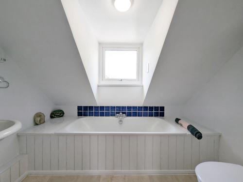 a white bath tub in a bathroom with a window at Frankland House in Emsworth