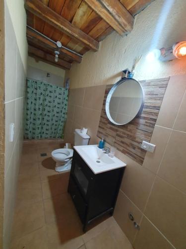 a bathroom with a sink and a mirror and a toilet at Casa Caminos del vino in Mendoza