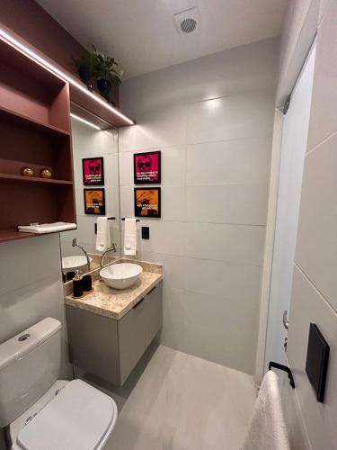 a bathroom with a white toilet and a sink at Studio Sunset João Pessoa in João Pessoa