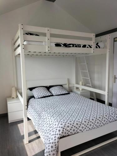 - une chambre avec des lits superposés blancs et une échelle dans l'établissement Studio charmant à Vierville-sur-Mer - 30m² avec jardin, à Vierville-sur-Mer