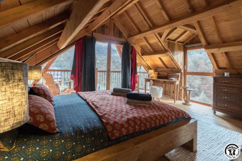 une chambre avec un lit dans une cabane en rondins dans l'établissement L'Escale Pyrénéenne, à Melles