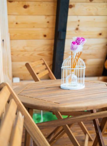 a wooden table with a bird cage with a flower in it at Eka's Village in Plav