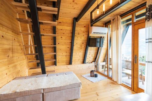 a living room with wooden walls and a couch at Eka's Village in Plav
