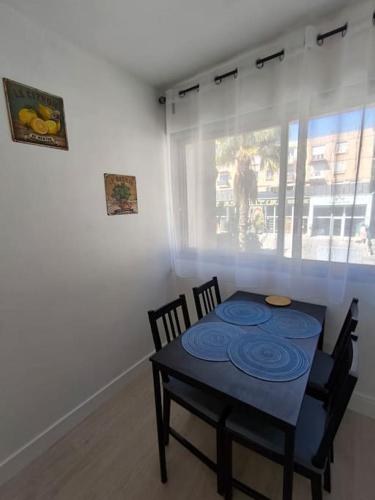 une salle à manger avec une table et des chaises bleues dans l'établissement Appartement T2 ensoleillé, au Lavandou