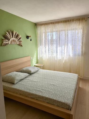 Ce lit se trouve dans un dortoir doté d'une fenêtre et d'un lit sidx sidx. dans l'établissement Appartement T2 ensoleillé, au Lavandou