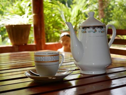 a tea pot and a cup on a wooden table at Pidurangala View Home Stay in Sigiriya