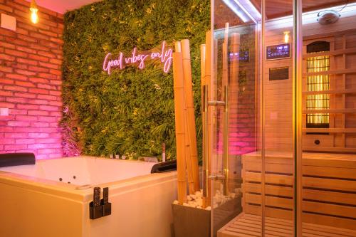 a bathroom with a bath tub and a green wall at Private Baltic Spa & Art Suite in Dziwnów