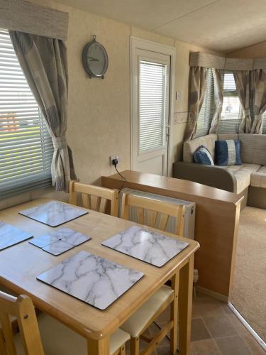 a dining room with a table and a bed at Blue 4 Caravan Ingoldmells 6 berth 3 bedrooms in Ingoldmells
