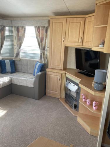 a small living room with a couch and a tv at Blue 4 Caravan Ingoldmells 6 berth 3 bedrooms in Ingoldmells