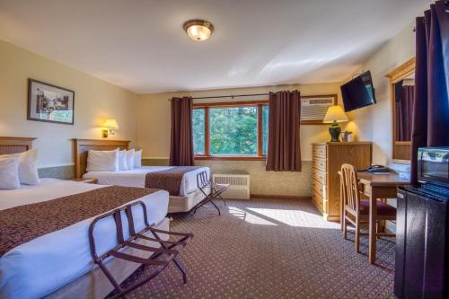 a hotel room with two beds and a television at Purity Spring Resort in Madison