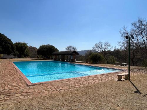 a swimming pool with a gazebo in a yard at Tonquani Bush Chalet in Rustenburg
