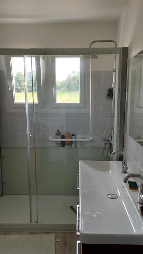 une salle de bain avec une douche en verre et un lavabo dans l'établissement Du jouet, à La Roche-Derrien