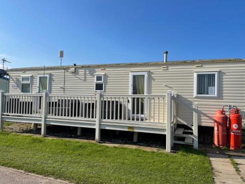 a mobile home with two fire hydrants and a fence at Yellow 3 Caravan Ingoldmells 6 berth 3 bedrooms in Skegness