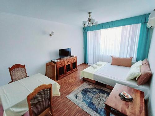 a bedroom with a bed and a tv and a table at Wild Cherry Apartments in St. St. Constantine and Helena