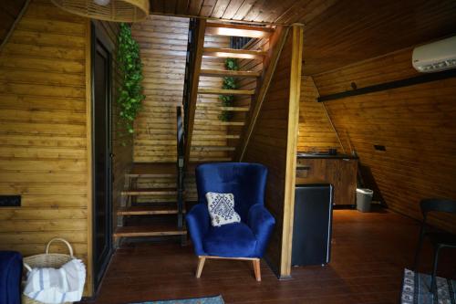 a blue chair in a room with a staircase at Villa Hideaway - Secluded A-Frame Stay in Sighnaghi