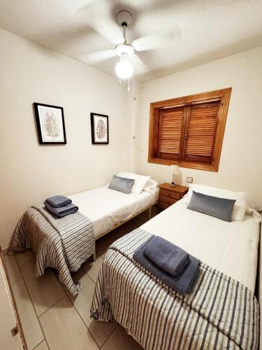 a bedroom with two beds and a ceiling at APARTAMENTOS ROSI - 5-10 Minute Walk To La Zenia Beach, Sea View, Beach Bar, Cliff Walk, Shops, Paddys Point, Cabo Roig - Free fast Fibre Optic Broadband, Free Parking, Tassimo coffee machine, TV Firestick compatible in Playas de Orihuela