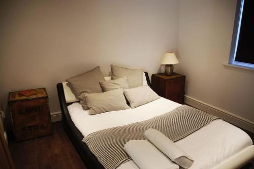 una camera da letto con un letto con lenzuola e cuscini bianchi di Lower Tundridge Cottage a Worcester