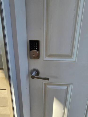 a door with a lock and a remote control on it at Cozy New 1 bed basement suite in Edmonton